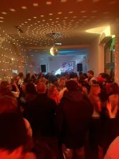 Orangenes Licht und Lichtmuster an der Decke über dunkler Menschenmenge.