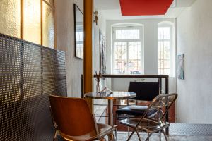 Sitznische am Fenster mit Metalltisch und Blick nach draußen.