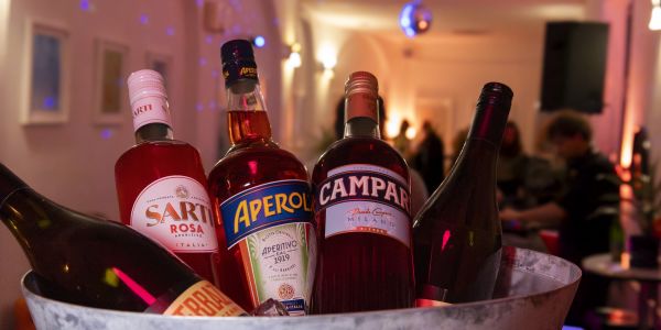Eiskübel mit Flaschen von Sarti Rosa, Aperol, Campari und Wein.