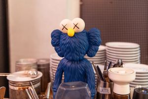 Blaue Figur zwischen Kaffeetassen und Geschirr auf der Theke.