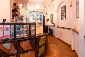 Verkaufstheke aus Holz und Glas mit Kuchen, Quiches und Order-Schild.