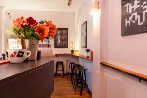 Rote Amaryllis-Blumen in Vase auf Theke neben weißer Kaffeetasse.